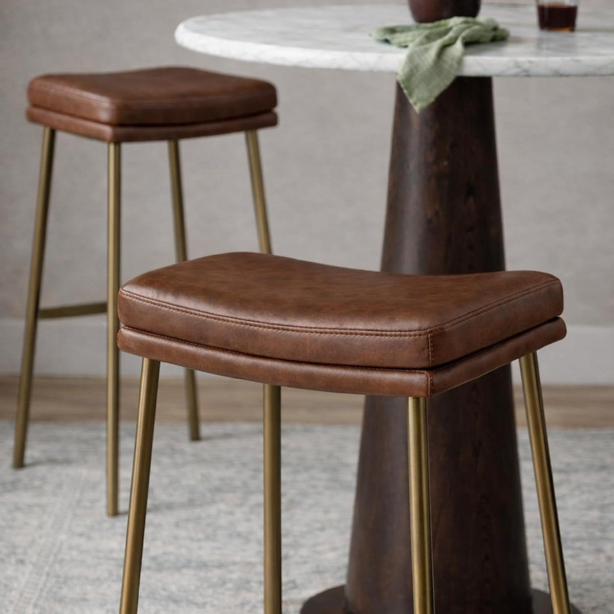 Maven Lane Berkley Backless Bar Stool 31 Inch – Saddle Stool with Footrest – Aged Gold Metal Frame & Brown Faux Leather Upholstery – Ideal for Bars, Pubs and Tall Kitchen Counters